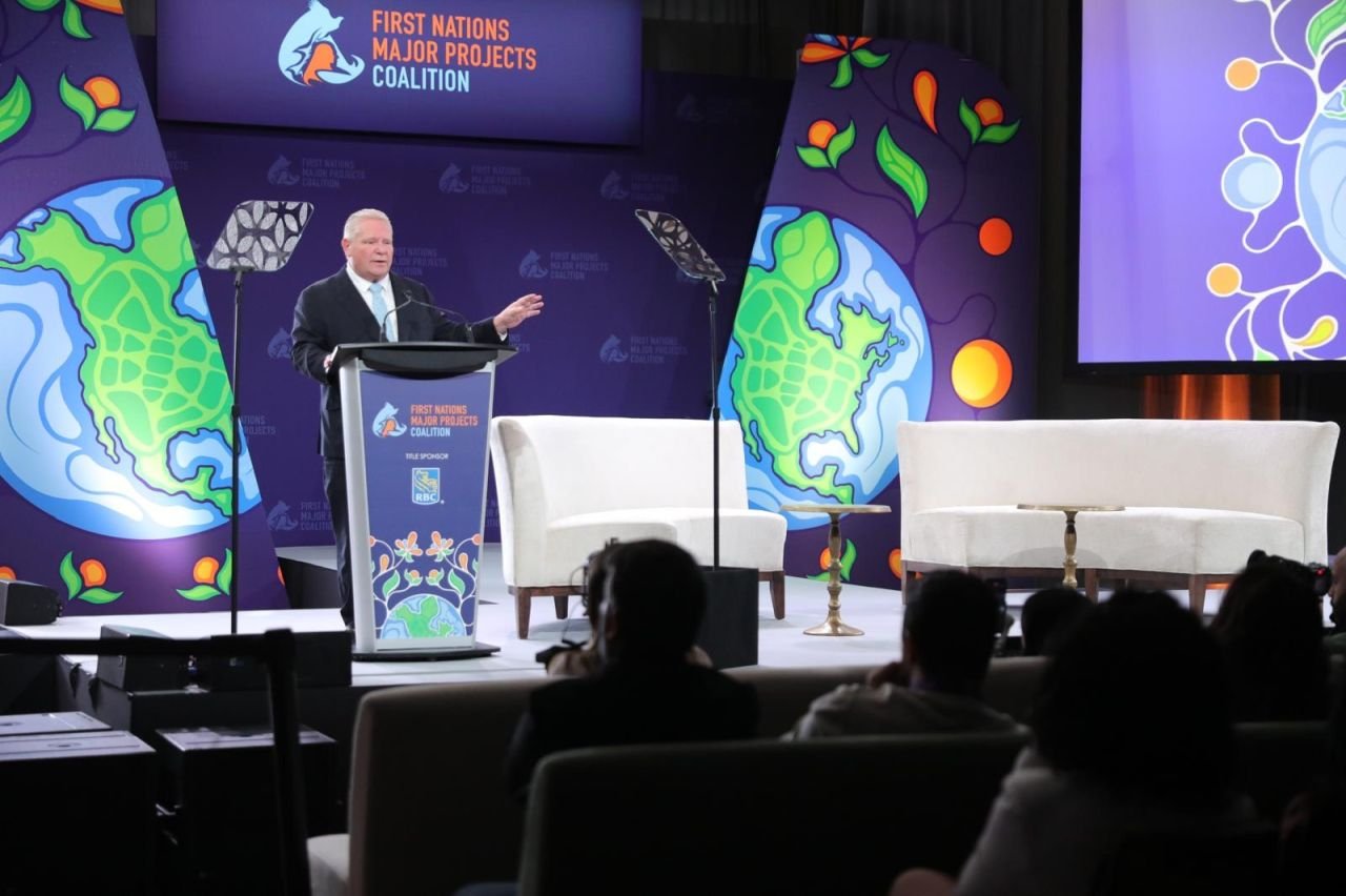 Speaker at the podium with the conference's earth graphic backdrop