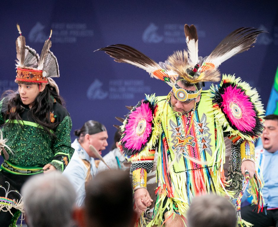 Traditional dancers in feather regalia performing on the First Nations Major Projects Coalition stage